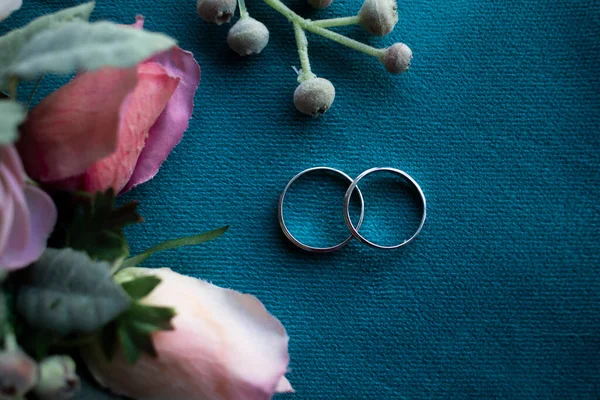 Photo Wedding Rings Flowers Blue Fabric Close — Stock Photo, Image