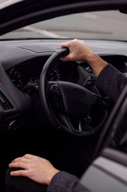 Adam arabanın direksiyonunda oturuyor. Yaklaş.