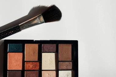 Kozmetik ve renkli göz gölgeleri beyaz arkaplanda izole edilmiş.