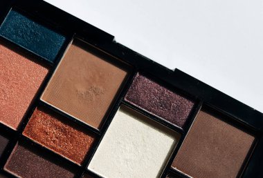 Kozmetik ve renkli göz gölgeleri beyaz arkaplanda izole edilmiş.