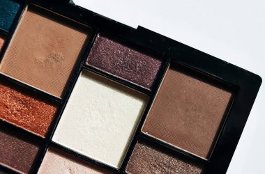 Kozmetik ve renkli göz gölgeleri beyaz arkaplanda izole edilmiş.