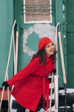 Trenin yanındaki tren istasyonunda bavullu kırmızı elbiseli kız. 