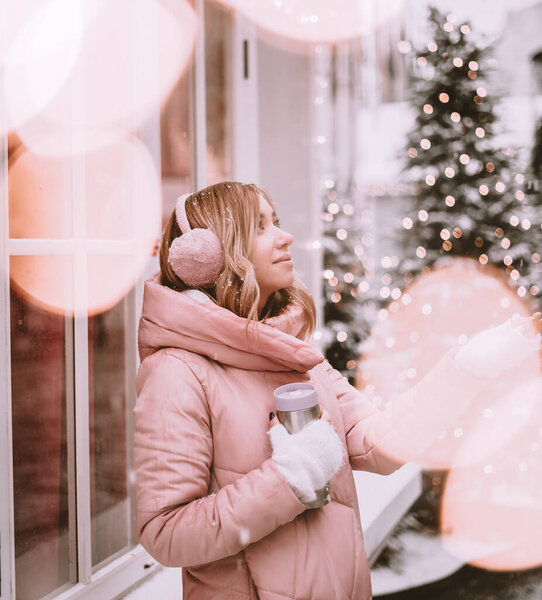 beautiful girl in the winter outdoors rejoices in the snow