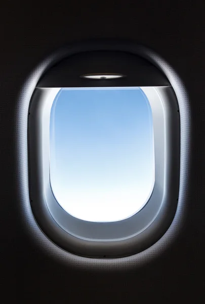Janela do avião e fantásticas nuvens brancas macias contra o céu azul — Fotografia de Stock
