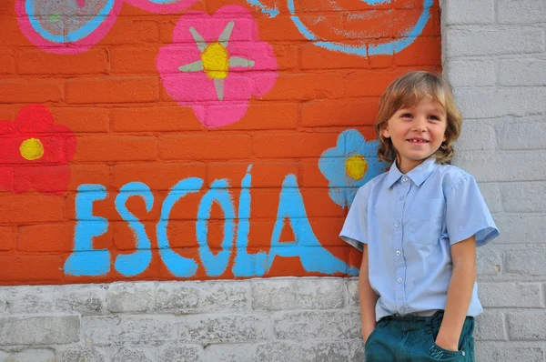 微笑的男孩在学校墙上 — 图库照片