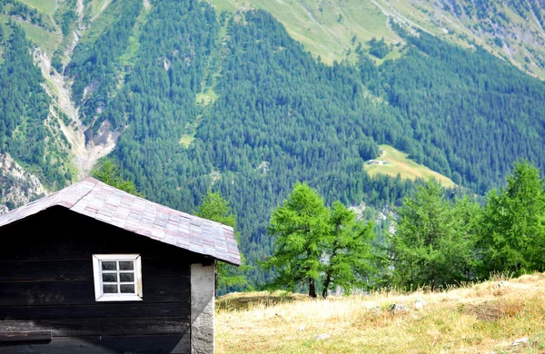 Schwarze Holzhütte in den Bergen — Stockfoto