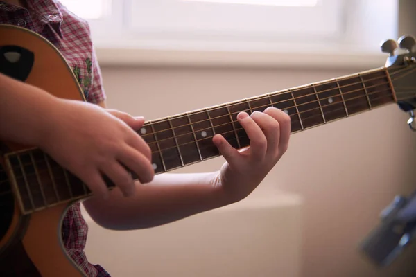 a little girl learns to play the guitar from notes. Music school for children.Musical notation.