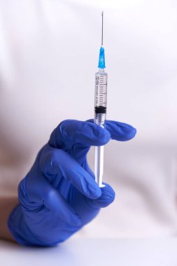 Bir kadın önünde bir şırınga tutuyor. Bir salgında aşı.