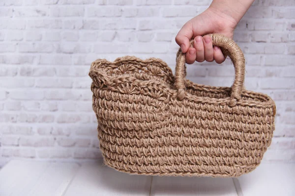 handmade knitted basket on a wooden table. Next to the thread in the skeins for yarn. Cozy arrangement of the house made of ecological materials