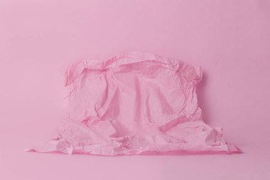 Ürününüz için pembe arka planda buruşmuş kağıdın üzerinde boş alan olan tek renkli resim. Pastel gözlük. Asgari konsept