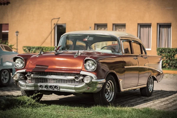 Voiture classique antique en bronze rouge debout contre le mur en terre cuite — Photo