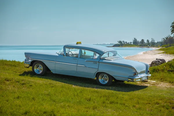 Vista del coche clásico retro vintage gris azulado estacionado en el acantilado verde cerca de la playa — Foto de Stock