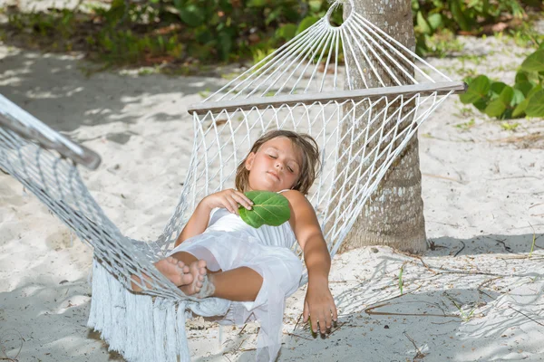 Trött liten tjej ligga och sova i hängmatta i tropisk trädgård — Stockfoto