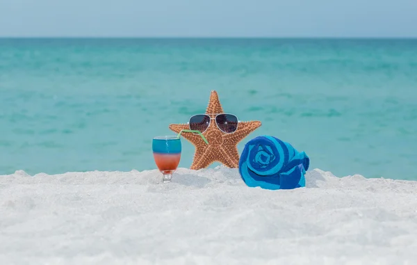 Αστερίες, πετσέτα και κοκτέιλ σε τροπική παραλία με λευκή άμμο — Φωτογραφία Αρχείου