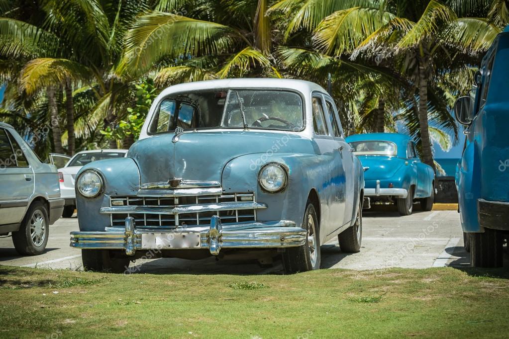 Vintage, retro classic cars parked in tropical garden near the beach
