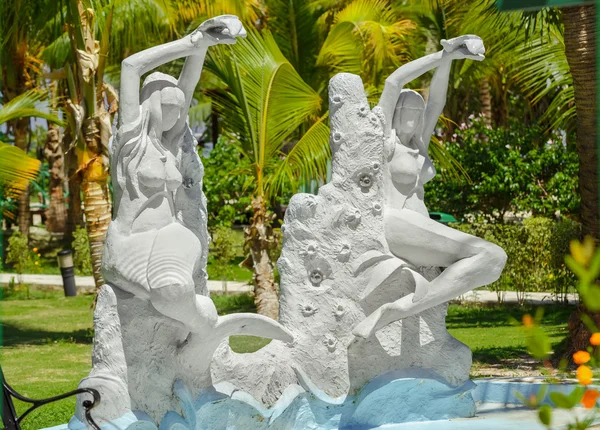 Scultura di sirena di mare mezza nuda e sirena seduta nel bellissimo giardino tropicale nella giornata di sole — Foto Stock