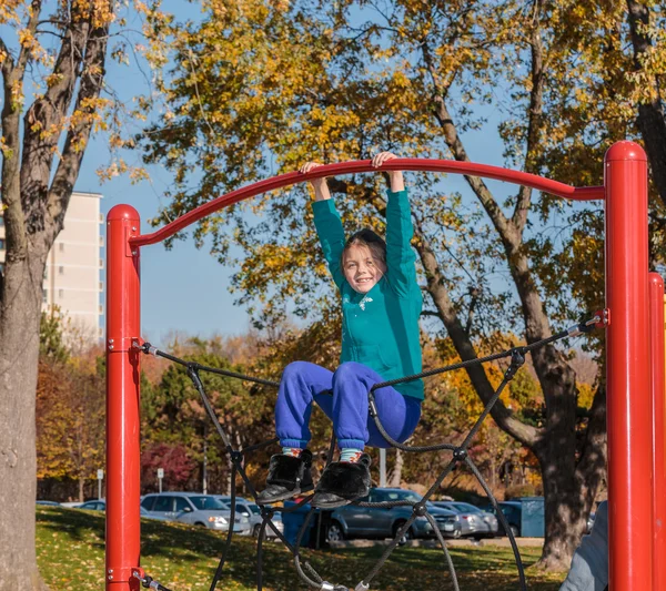 Grappig, vreugdevolle meisje spelen op kinderen speelplaats in het park — Stockfoto