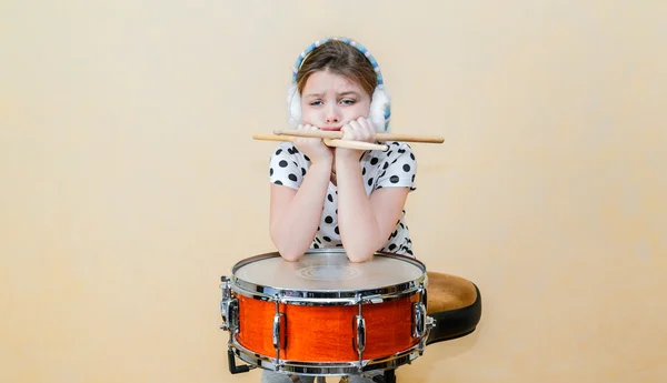 Primo piano vista di infelice, sconvolto noioso bambina seduta e pensare dietro il rullante tamburo — Foto Stock