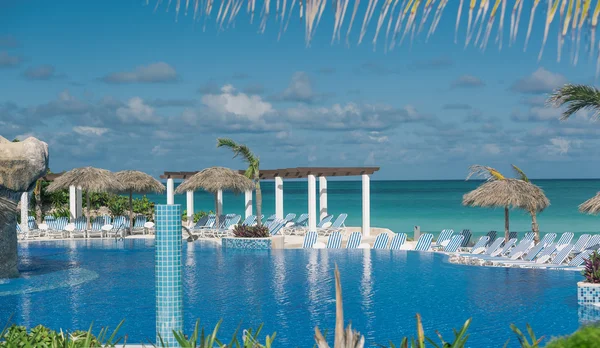 Increíble vista de la piscina tropical contra el océano tranquilo y el fondo azul del cielo — Foto de Stock