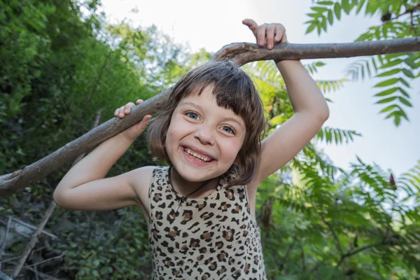 Joyful glad liten flicka med roliga ansikte spelar i park — Stockfoto