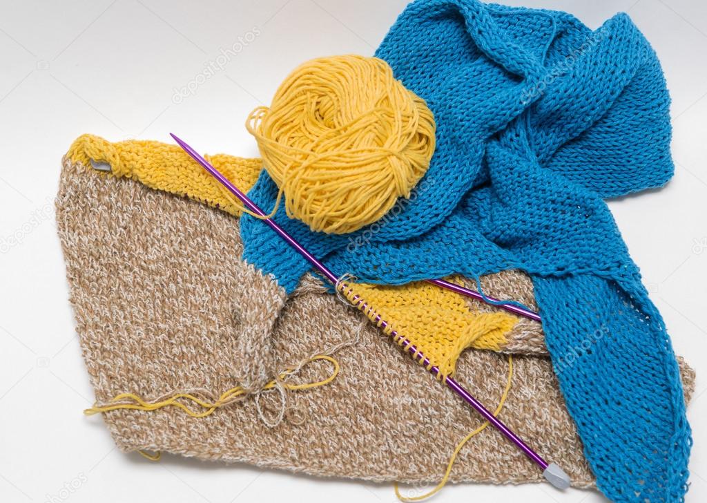 View of colorful yarn and needles cotton knitting craft on grey