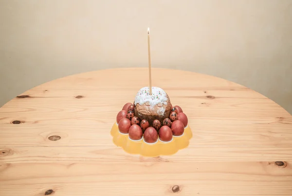 Belos ovos de férias de Páscoa, torta e vela ardente na mesa de madeira — Fotografia de Stock