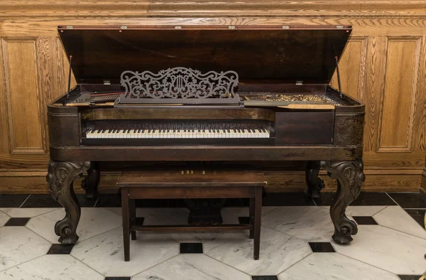Viejo hermoso magnífico vintage piano de pie sobre fondo de madera — Foto de Stock