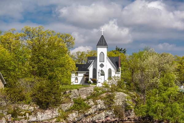 Mooie nodigen bekijken van oude vintage witte kerk staande op een rots rots in bos — Stockfoto