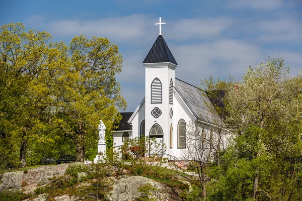 Great view of old vintage white church standing on a rock cliff in woods — Stock Photo, Image