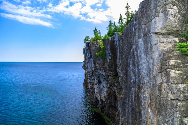 View of big long rocky cliff standing in Cyprus lake against blue bright sky background — ストック写真