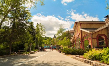 Collingwood, Ontario, Kanada, 12 Haziran 2021, Blue Mountain Village tatil köyünün harika manzarası, barlı otel alanları, restoranlar, kafeler, arka planda yürüyen insanlar, güneşli bir gün.