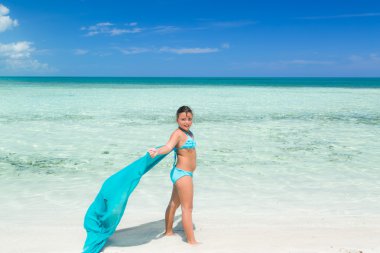 portrait of pretty styled happy smiling  fashionable little girl standing on the beach on sunny summer day