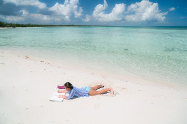 nice amazing gorgeous view of a little girl lying on white sand beach