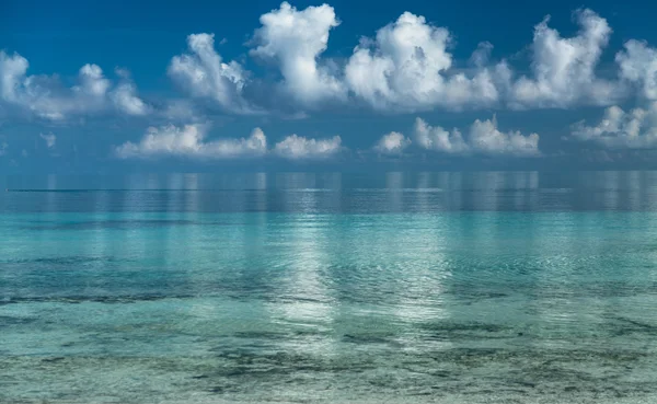 Splendid amazing inviting view of early morning ocean and white fluffy clouds reflected in water background — Zdjęcie stockowe