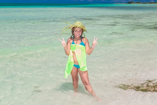 Closeup view of beautiful fashionable pretty little girl standing in tranquil turquoise ocean — Stok fotoğraf