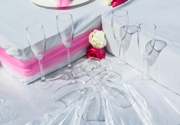 Beautiful closeup view of wedding decorated part of table with glasses and roses on white sheet or cloth — Stock Photo, Image