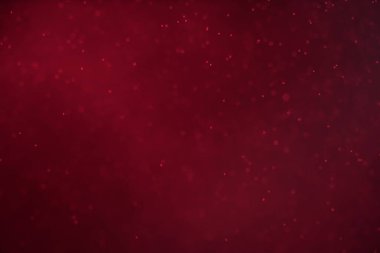 Seçici odaklı soyut şenlik arkaplanı. Koyu kırmızı zemin üzerinde parlak parçacıklar. Sıçramalar, boşluk, enerji akışı