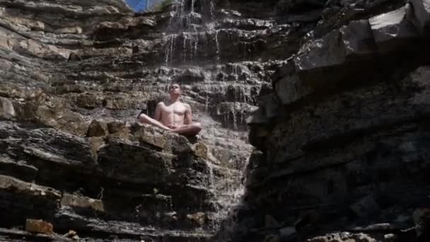 Muž medituje o vodopádu — Stock video
