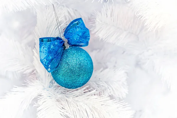 Mavi Noel topları beyaz yapay köknar ağacına asılı..