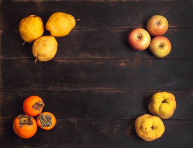 Çeşitli sonbahar meyveleri kopya alanı ile ahşap arkaplan köşelerinde yatar.