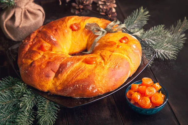 Köknar dallarının arka planında portakallı meyveli maya hamuru şeklinde ev yapımı Noel ekmeği..