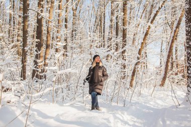 Kışın çam ormanındaki kadın Ağaçlarda kar ve güneşli bir günde zemin.