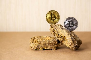 Gold and silver Bitcoin Coins balances on natural stones on light background. Blockchain cryptocurrency, store of value.