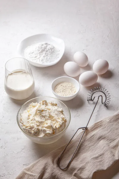 Bask İspanyolcası pişirmek için gereken malzemeler yanmış Aziz Sebastian peynirli keki. Pişirme ürünleri - krem peynir, şeker, yumurta, un ve krema. Tarif adım adım düz düz üst görünüm.