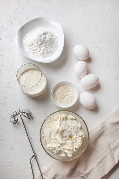 Bask İspanyolcası pişirmek için gereken malzemeler yanmış Aziz Sebastian peynirli keki. Pişirme ürünleri - krem peynir, şeker, yumurta, un ve krema. Tarif adım adım düz düz üst görünüm.