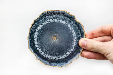 Gri standı epoksi reçineden yapılmış ve elinde altın pullar var. İç mekan için modern dekoratif öğe