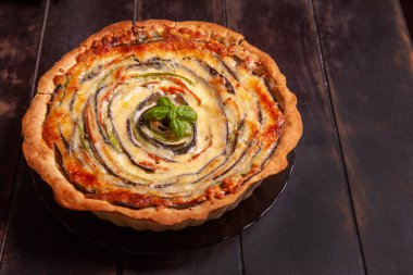 Sebzeli sarımsaklı tart, kabak, patlıcan, ahşap arka planda havuç.