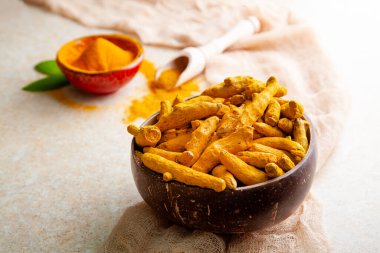 Hindistan cevizi kabuğunda kurumuş zerdeçal kökleri ve yapraklı toz.