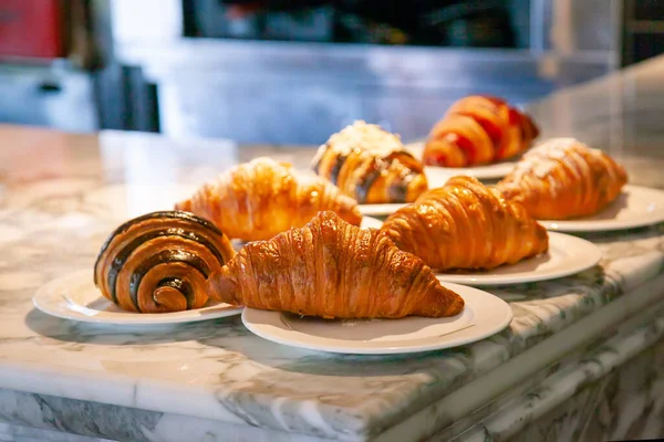 Several croissants are placed on the marble table before serving.