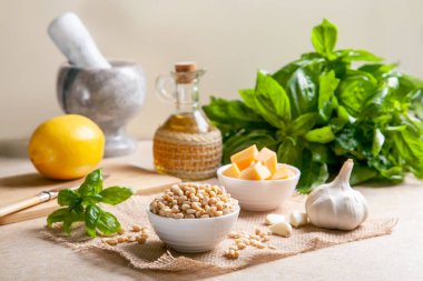 Evde pesto sosu yapma süreci. Kadın sos yapmak için havana fesleğen yapraklı zeytinyağı döküyor..